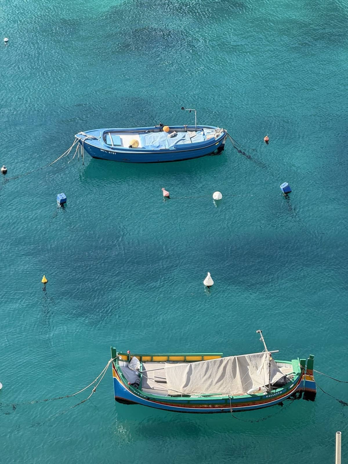 Two small boats moored on clear turquoise water seen from above