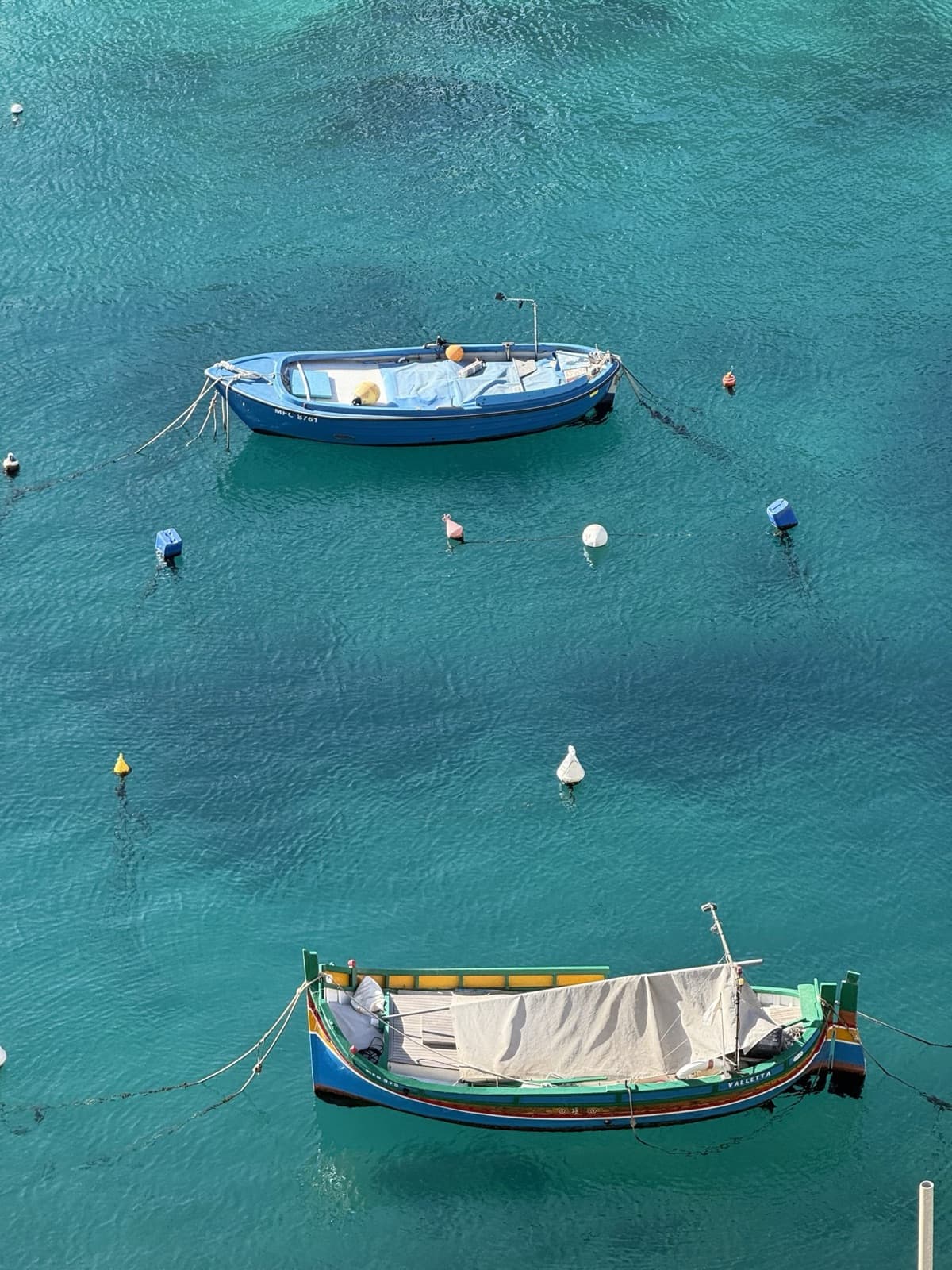 Two small boats moored on clear turquoise water seen from above